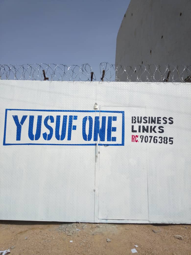 Yusuf One Business Links signage painted on the warehouse perimeter wall