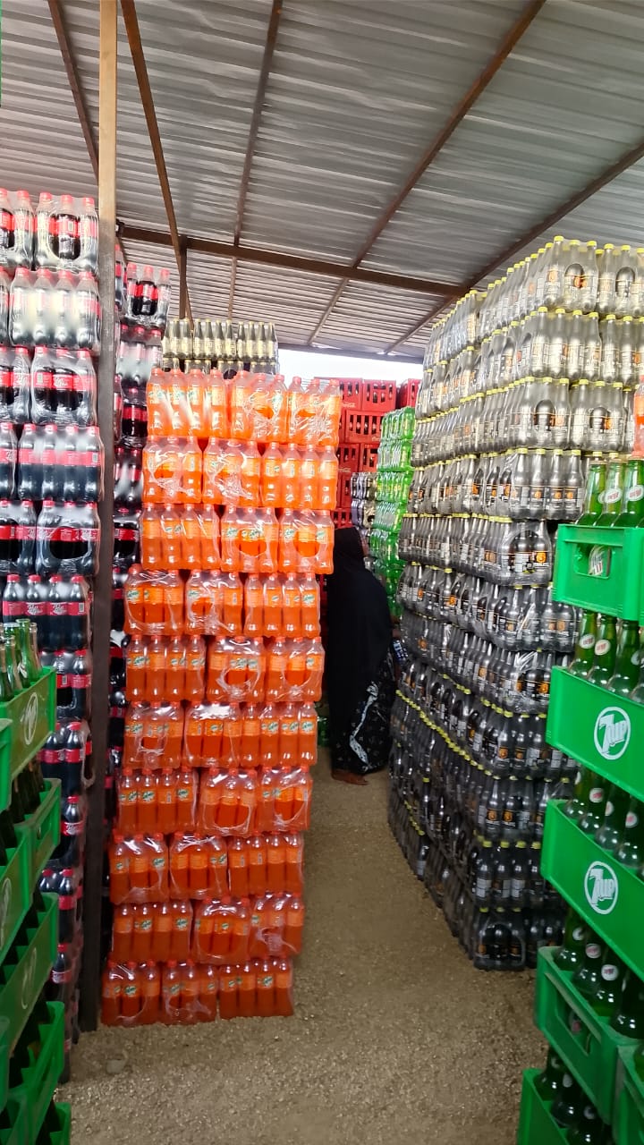 Warehouse aisle stocked with Coca-Cola, Fanta and 7Up crates